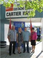 Le conseiller municipal Bowden; la d&eacute;put&eacute;e Hoeppner; Joe Lamoureux, pr&eacute;sident du club de hockey; et Mavis Tallieu, d&eacute;put&eacute;e de Morris, devant la salle Cartier, &agrave; Saint-Eustache.
