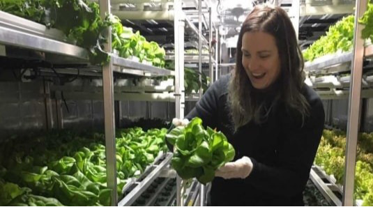 Femme tenant une tête de laitue cultivée à Churchill, au Manitoba